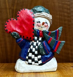 Snowman holding a heart wood carving